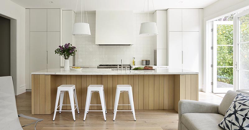 white kitchen with light wood island