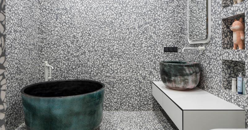White And Grey Terrazzo Tile Completely Cover The Walls And Floor Of This Bathroom With Soaking Tub