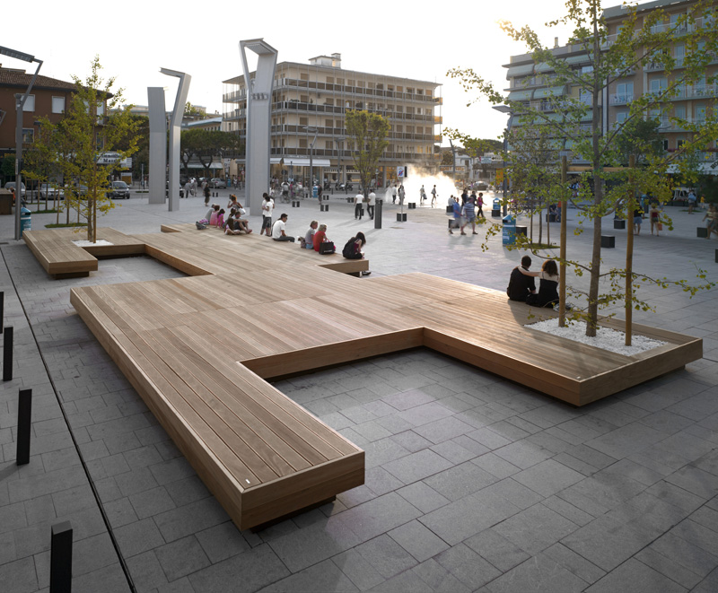 A Large Bench Serves As A Gathering Place In This Town Square