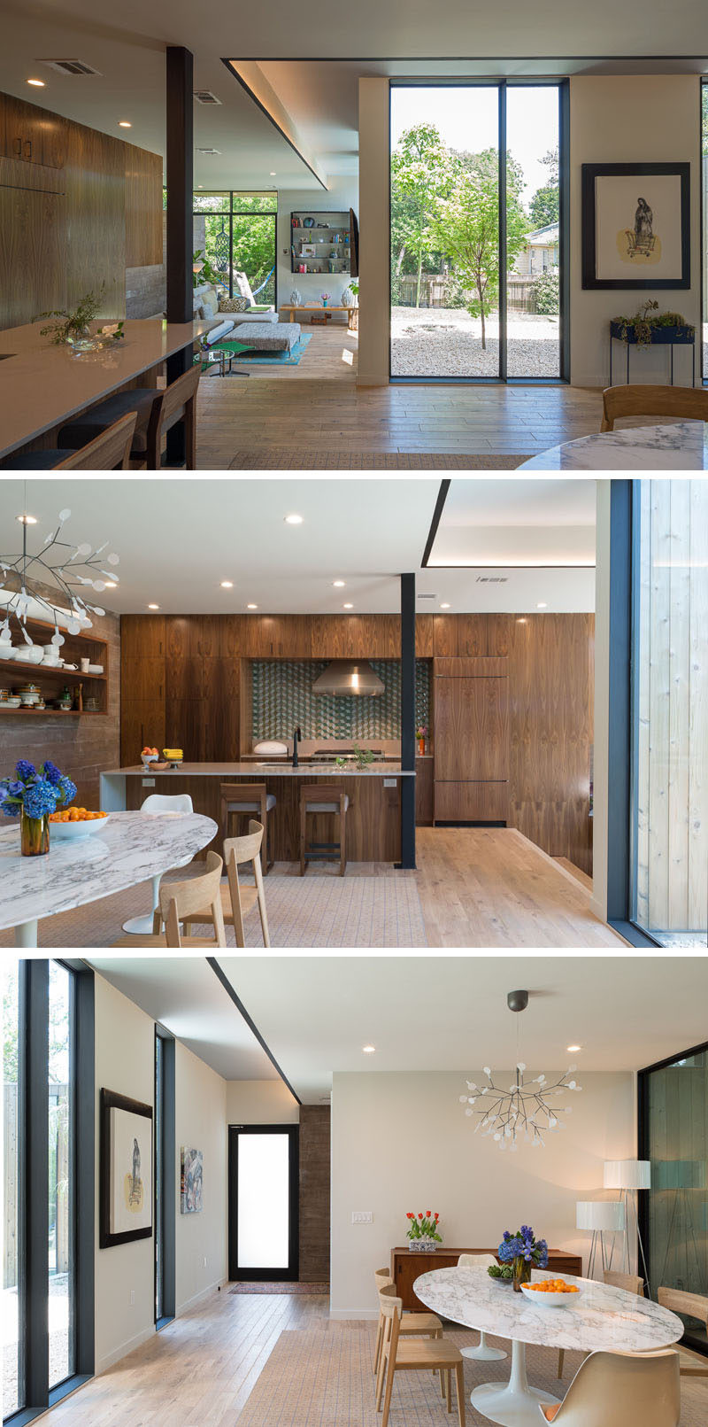 Stepped up from the living room in this house, is the kitchen and dining room. Wooden kitchen cabinets line the wall, with the island incorporating a column into its design. A sculptural chandelier helps to anchor the dining area in the space.