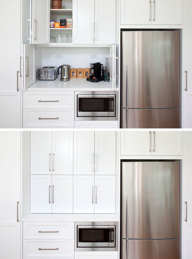 Kitchen Design Idea - Store Your Kitchen Appliances In A Dedicated Appliance // 折りたたみ式のドアで電子レンジの上のスペースが隠されていますが、このスペースは複数の家電製品を収納するのに十分な大きさで、快適なお茶を入れるのに必要なものはすべて揃っています。 #ApplianceGarage #KitchenIdeas #KitchenDesign