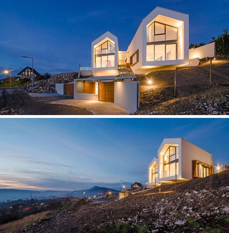 A House With Two Gable Roofs Sits On A Hillside Overlooking The Valley