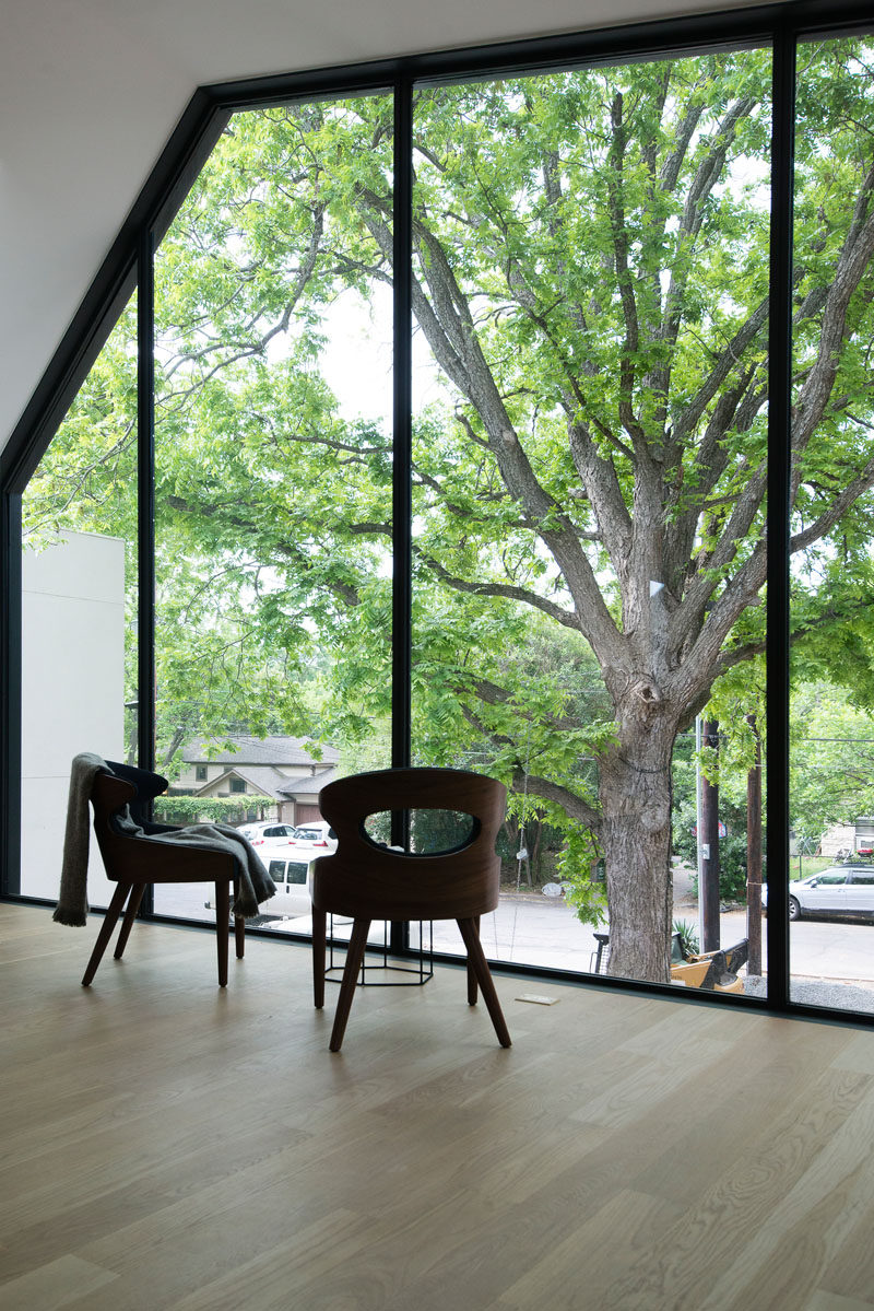 Large windows in this modern bedroom provide views of the trees and the street below. #LargeWindows #WindowDesign #Windows