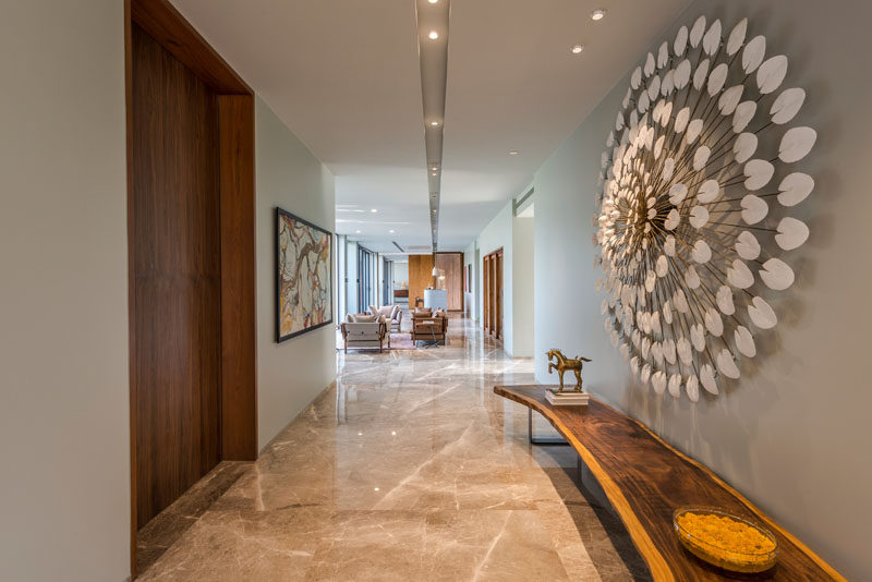 This contemporary house has an entry hallway furnished with a live-edge bench and sculptural artwork. #Entryway #Hallway #InteriorDesign