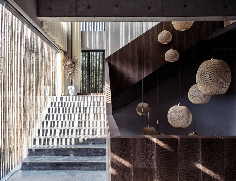 Rich wood and concrete stairs, shaded by a bamboo screen, leads to the upper floors of this modern hotel. #Stairs #ModernStairs