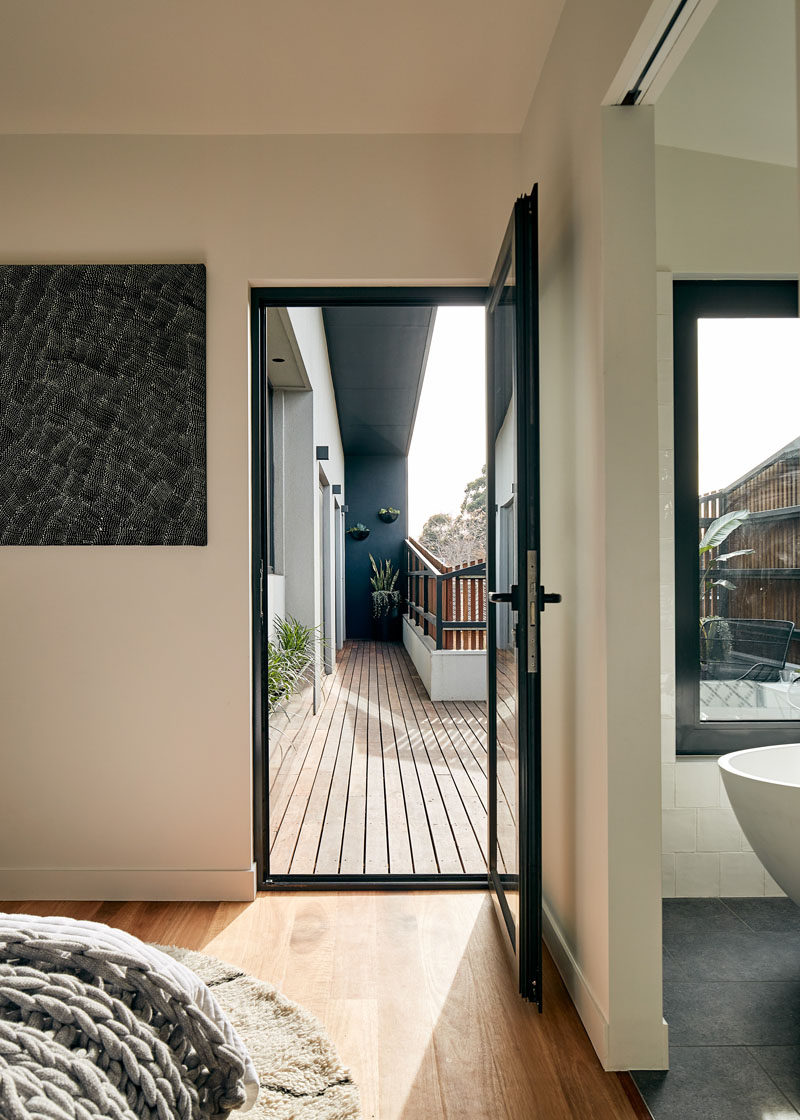 In this modern master bedroom, wood flooring has been used to add warmth to the room, and a glass door opens to a balcony. #Bedroom #WoodFloor #GlassDoor #Balcony
