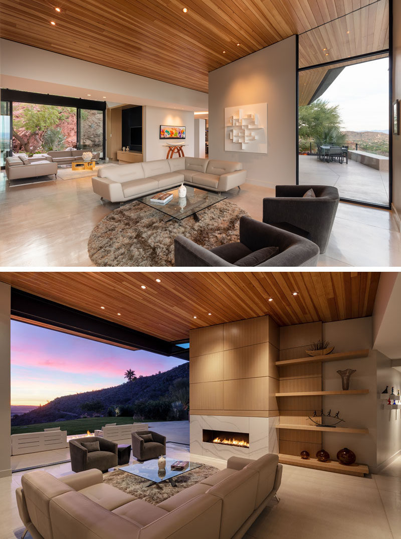 This modern living room has a fireplace and open shelving, while large sliding glass doors open the room to the outdoors. #LivingRoom #Fireplace #Shelving