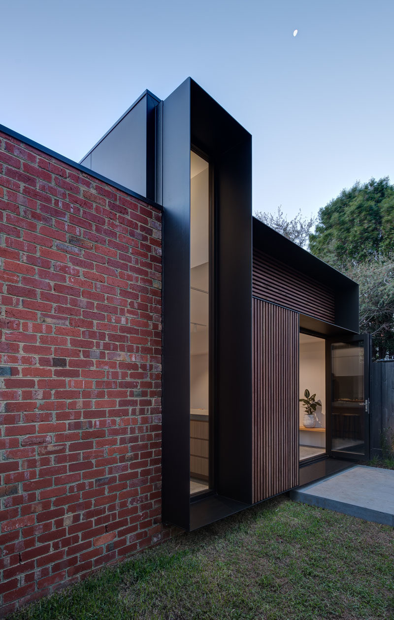 Window Ideas - This modern vertical window with a deep black steel frame, measures in at over 14 feet (4.5m) high and frames the large gum tree on the rear property. #WindowIdeas #WindowDesign