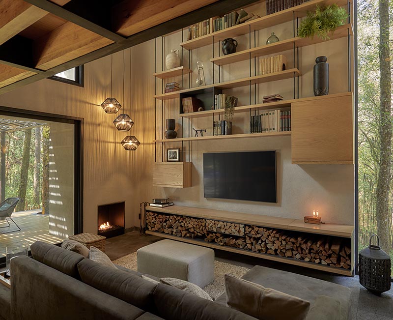 A modern living room with open wood shelving that lines the wall and includes firewood storage.