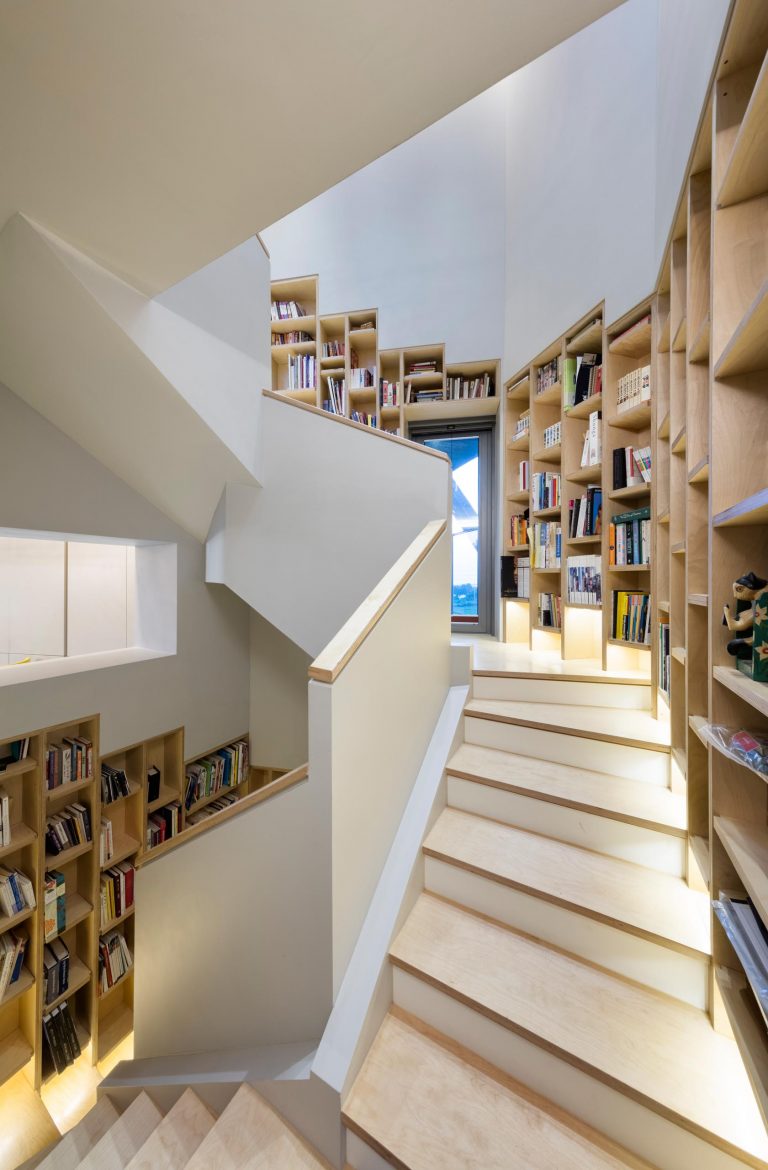 A Built-In Bookshelf Follows The Stairs Inside This Home