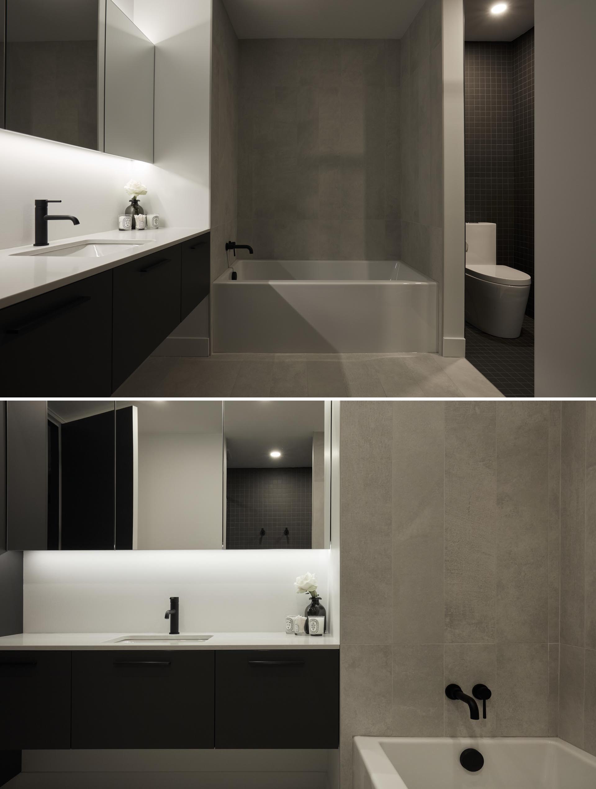 The design of this modern bathroom has been separated into zones. The light zone combines the vanity, the medicine cabinet, and the bath, while the dark zone combines the toilet and a shower with built-in shelving niche.