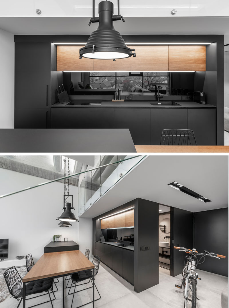 Design firm IDwhite has completed the interiors of a modern industrial loft with a black kitchen.