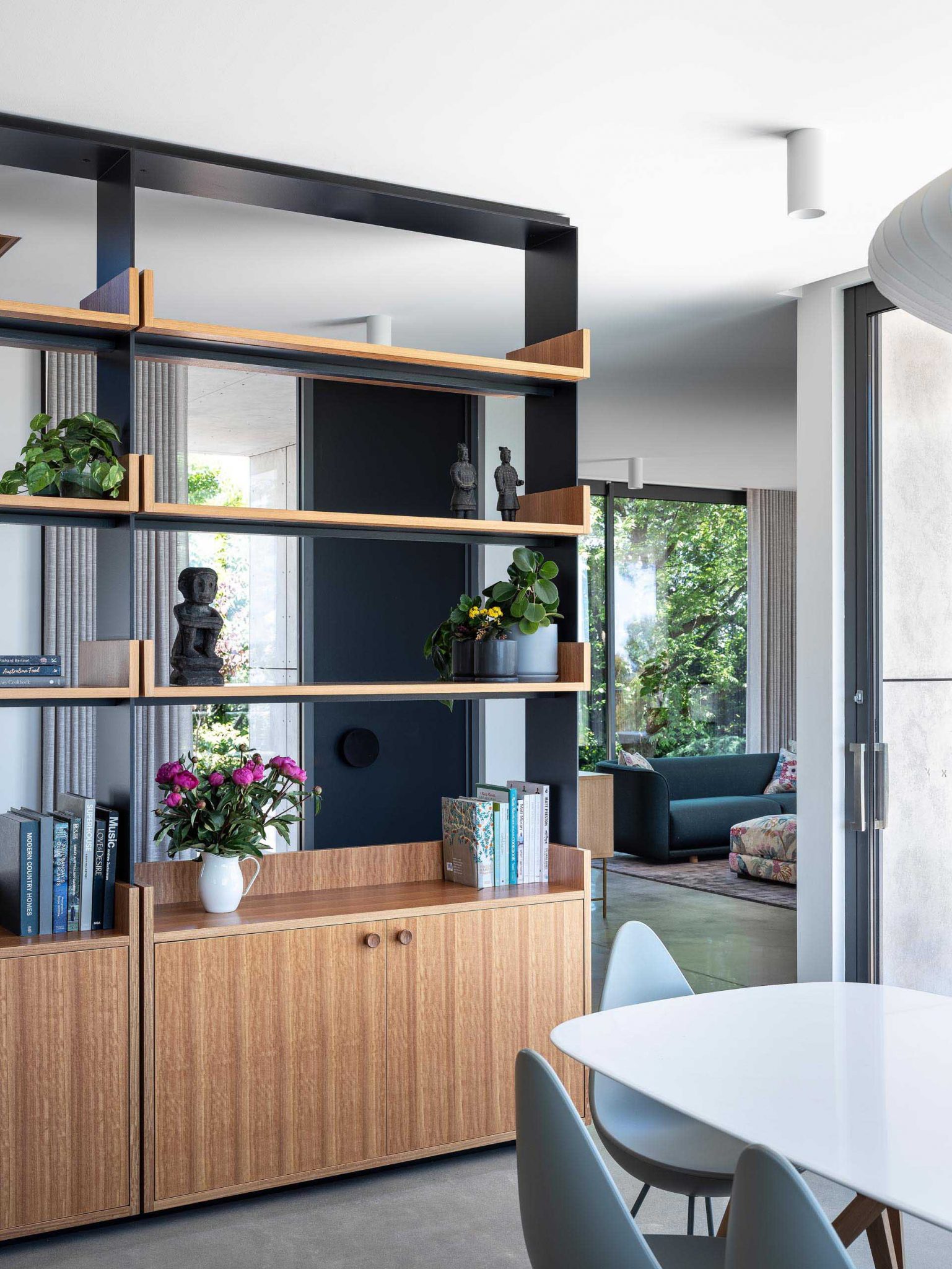 An Open Shelving Unit Is Used As A Partition To Create A Hallway Inside ...