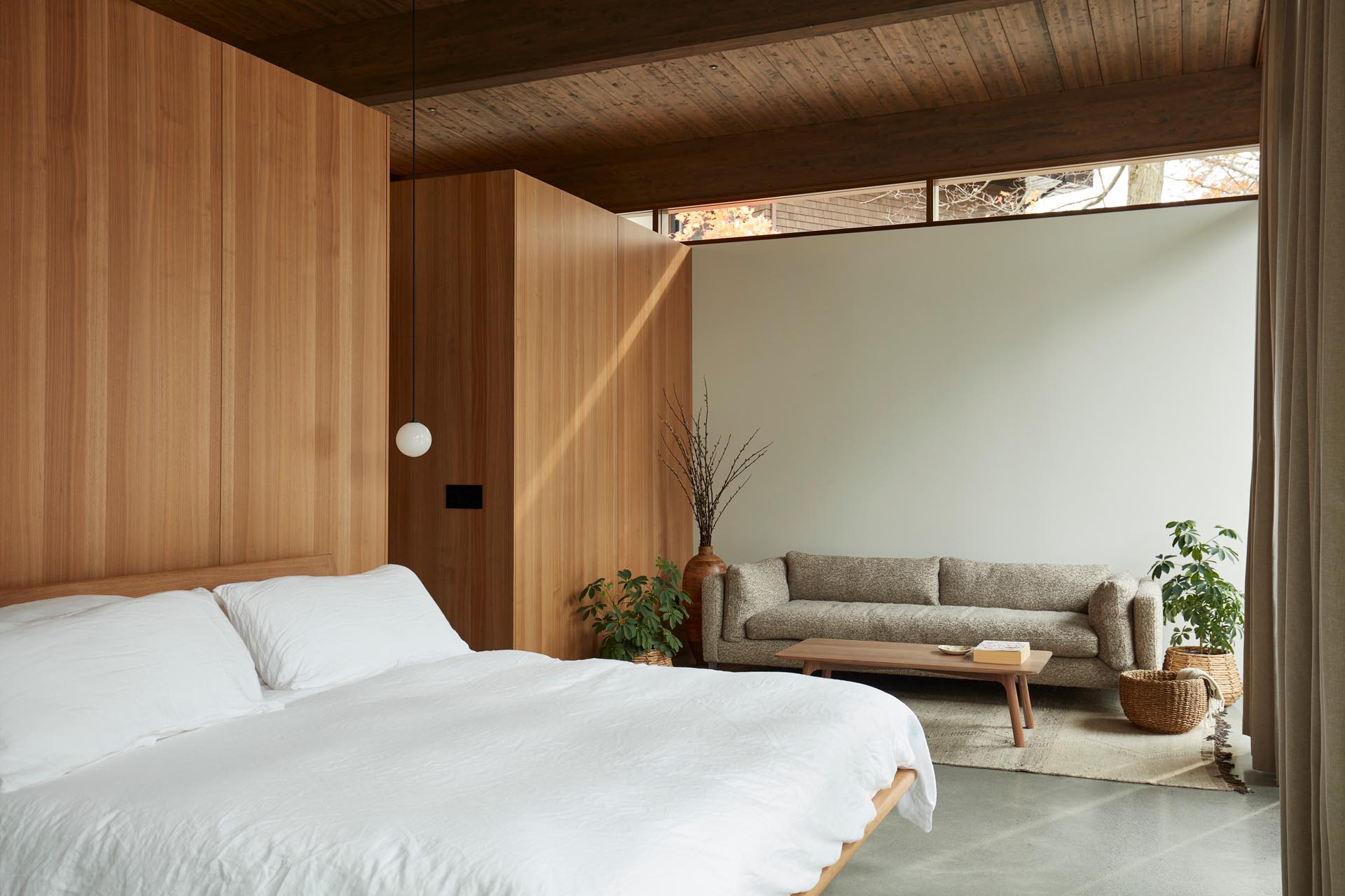 In this modern bedroom, custom wood closets serve as the backdrop for the bed.