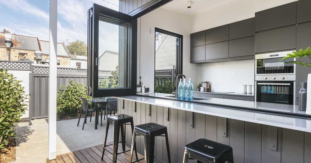A Wall Of Bi-Fold Windows Open This Kitchen To The Outdoors