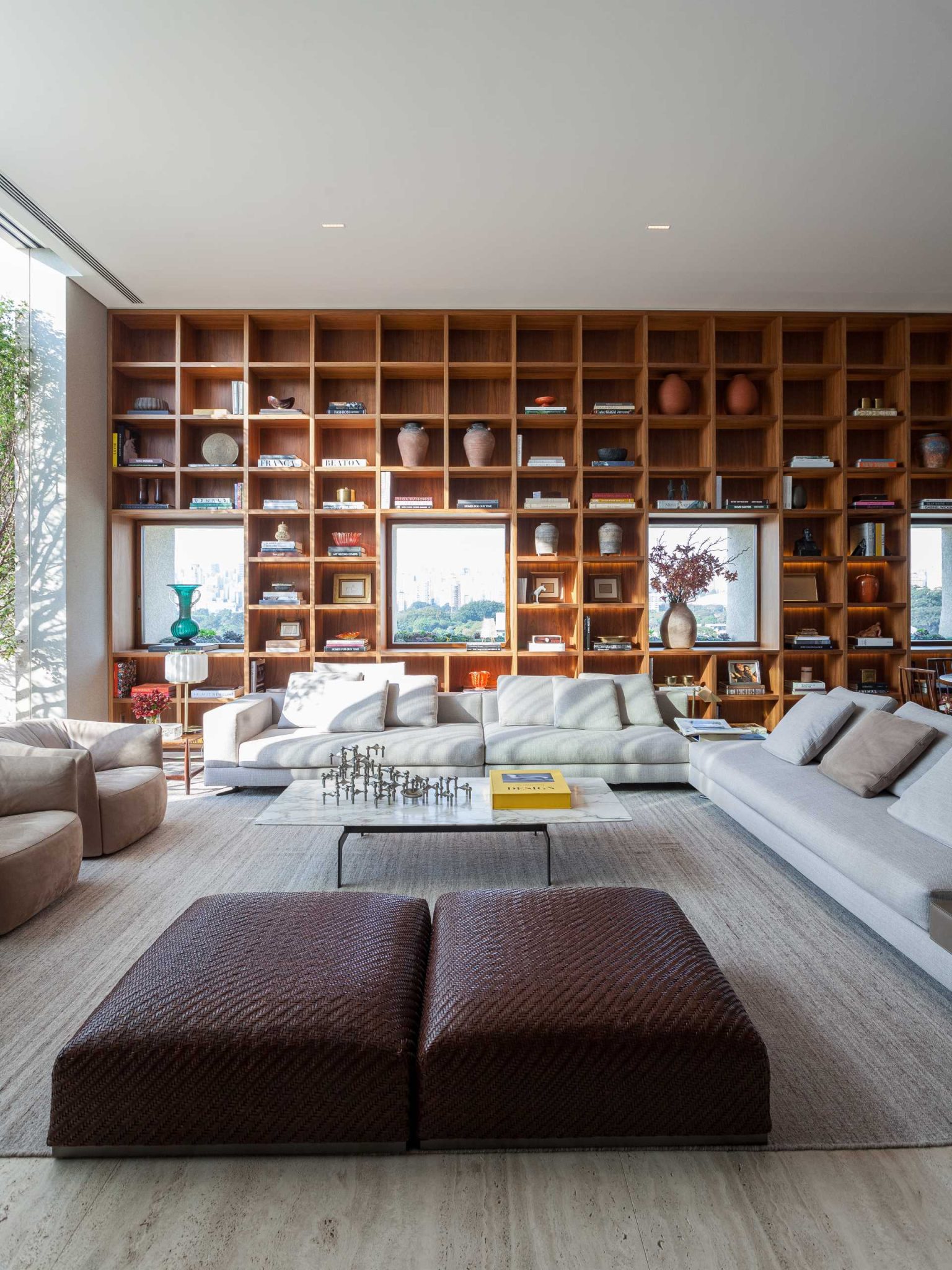 a-full-wall-bookshelf-with-led-lighting-frames-the-windows-like-artwork