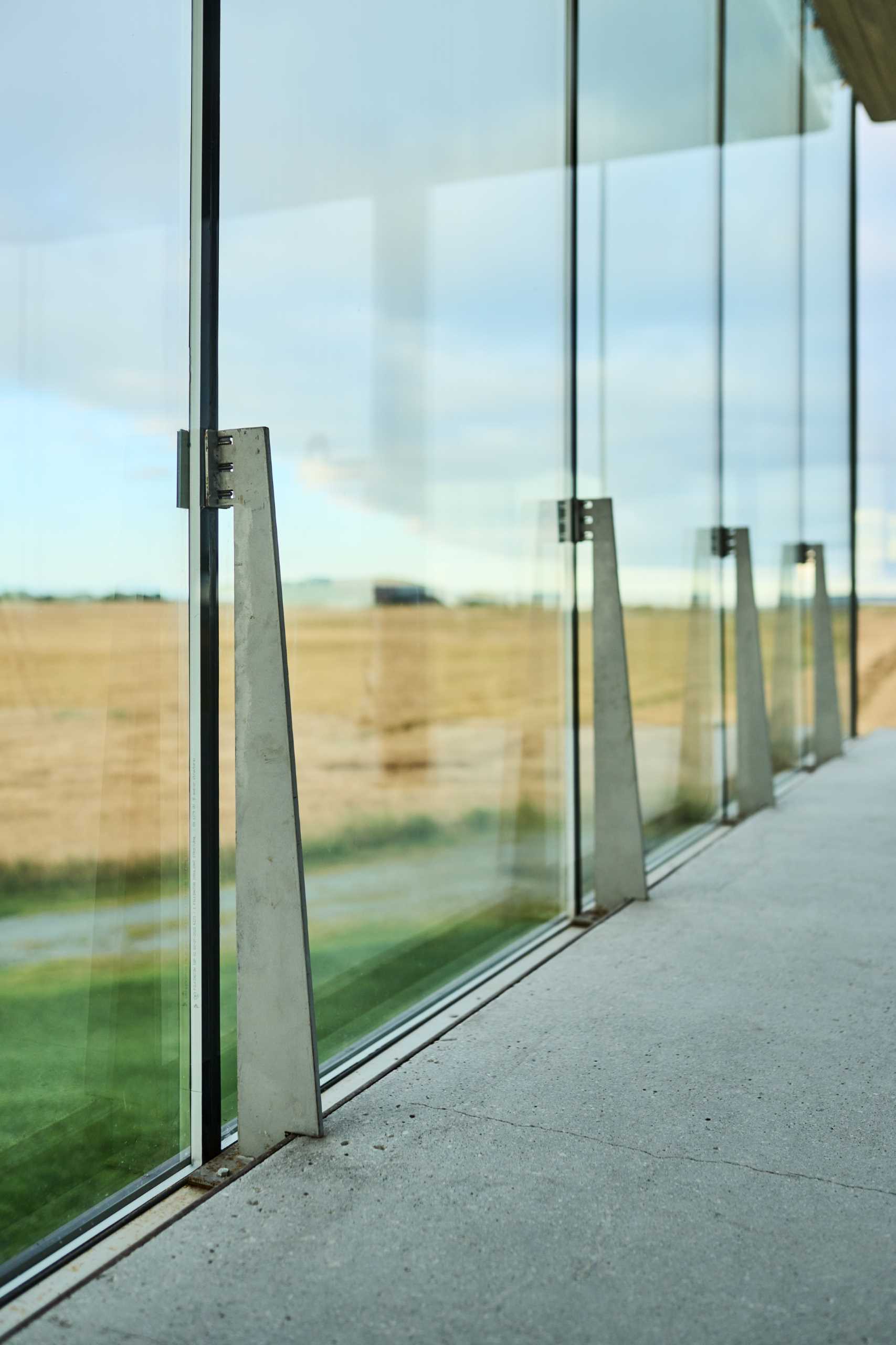 Floor-to-ceiling windows have steel supports holding them in place.