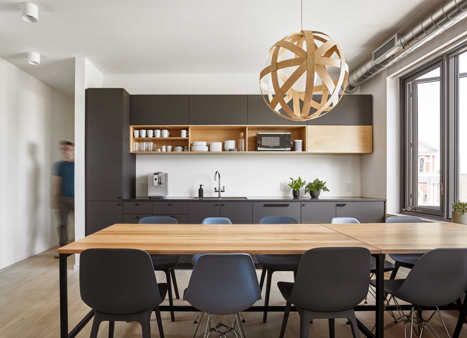 The matte black cabinets in the kitchen provide a backdrop for team lunches and group meetings.