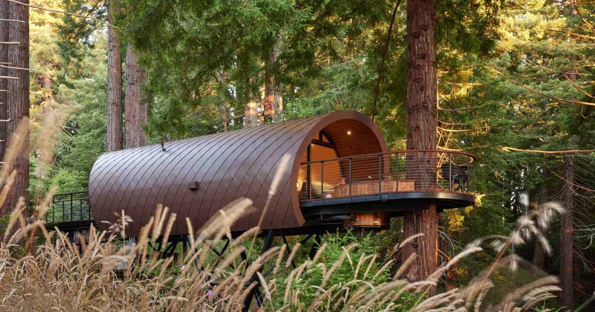 A Tube Shaped Treehouse Wrapped In Diamond-Shaped Metal Tiles