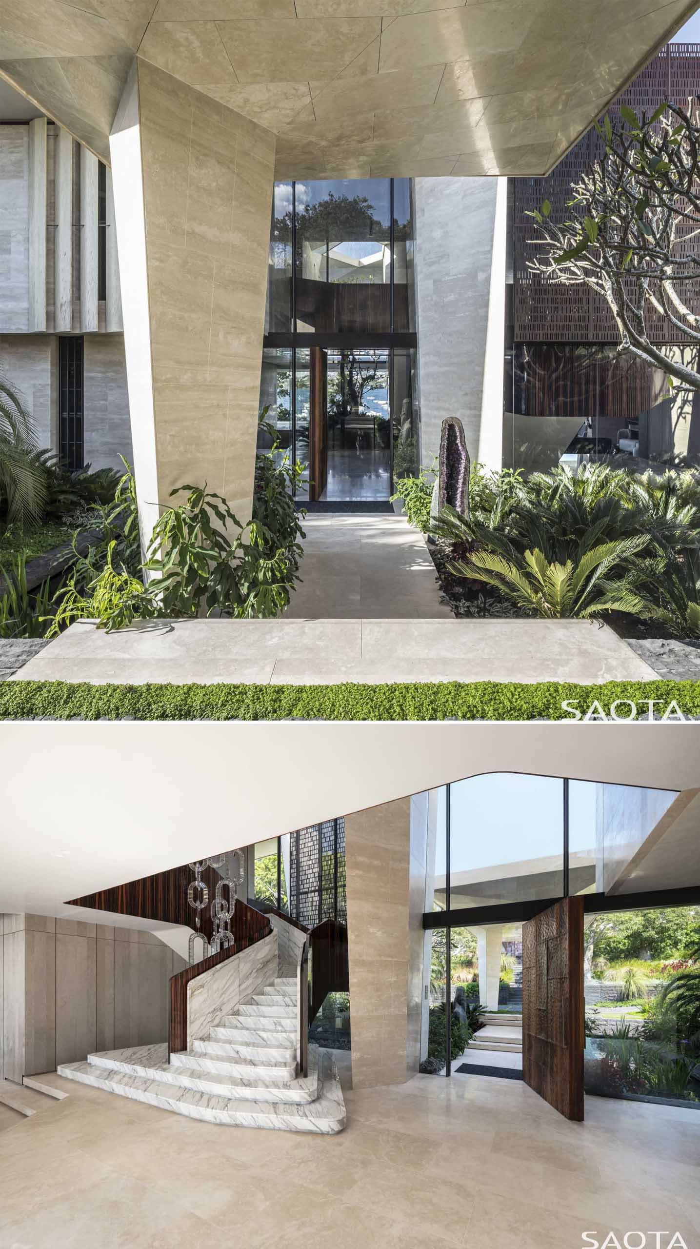 The ،use has a sculpted stone form that leads to the front door and foyer. From the foyer, views of the water and a tree are visible.