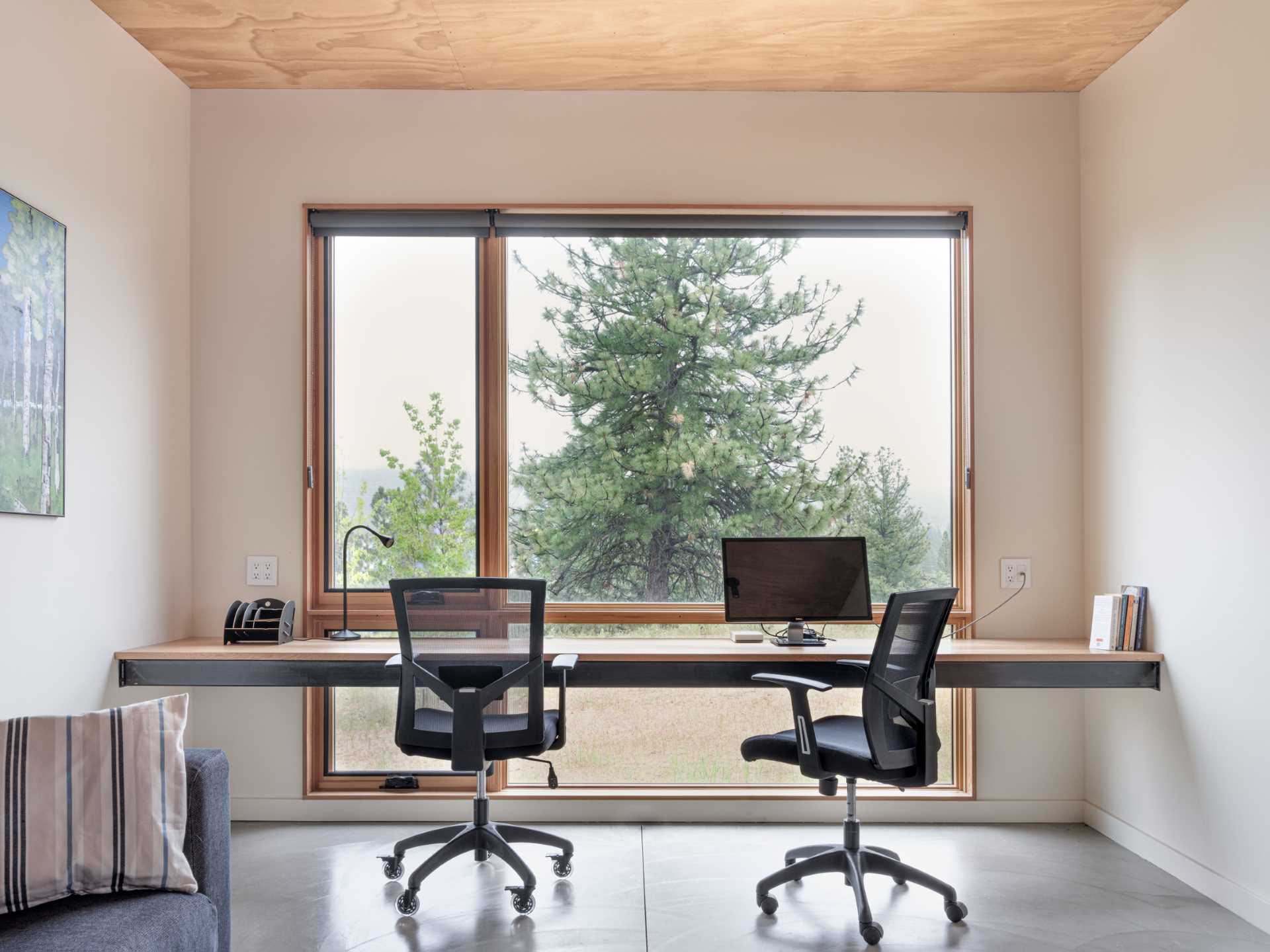 In a room that's dedicated to being a home office for two, a floating wood desk with a steel frame is positioned to take advantage of the views.