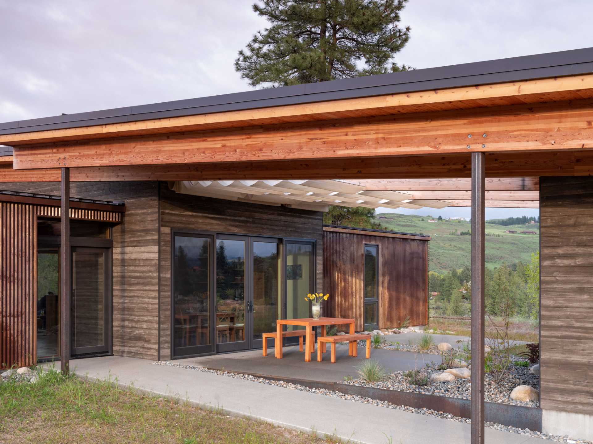 The exposed glulam beams of the roof support retractable awnings, giving the space flexibility and providing additional shade and cooling to the rest of the home.
