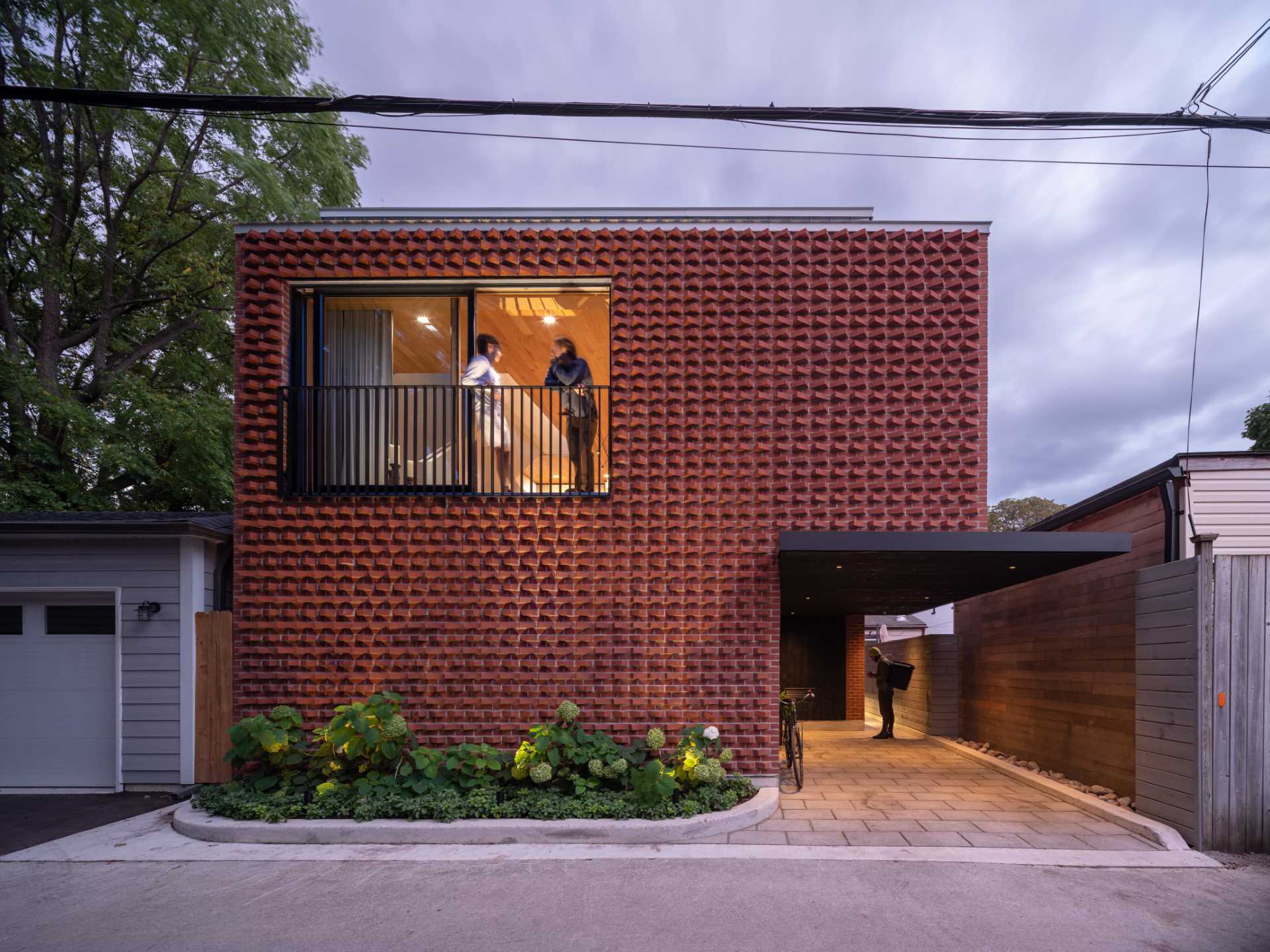 A modern laneway house with a rotated red brick facade.