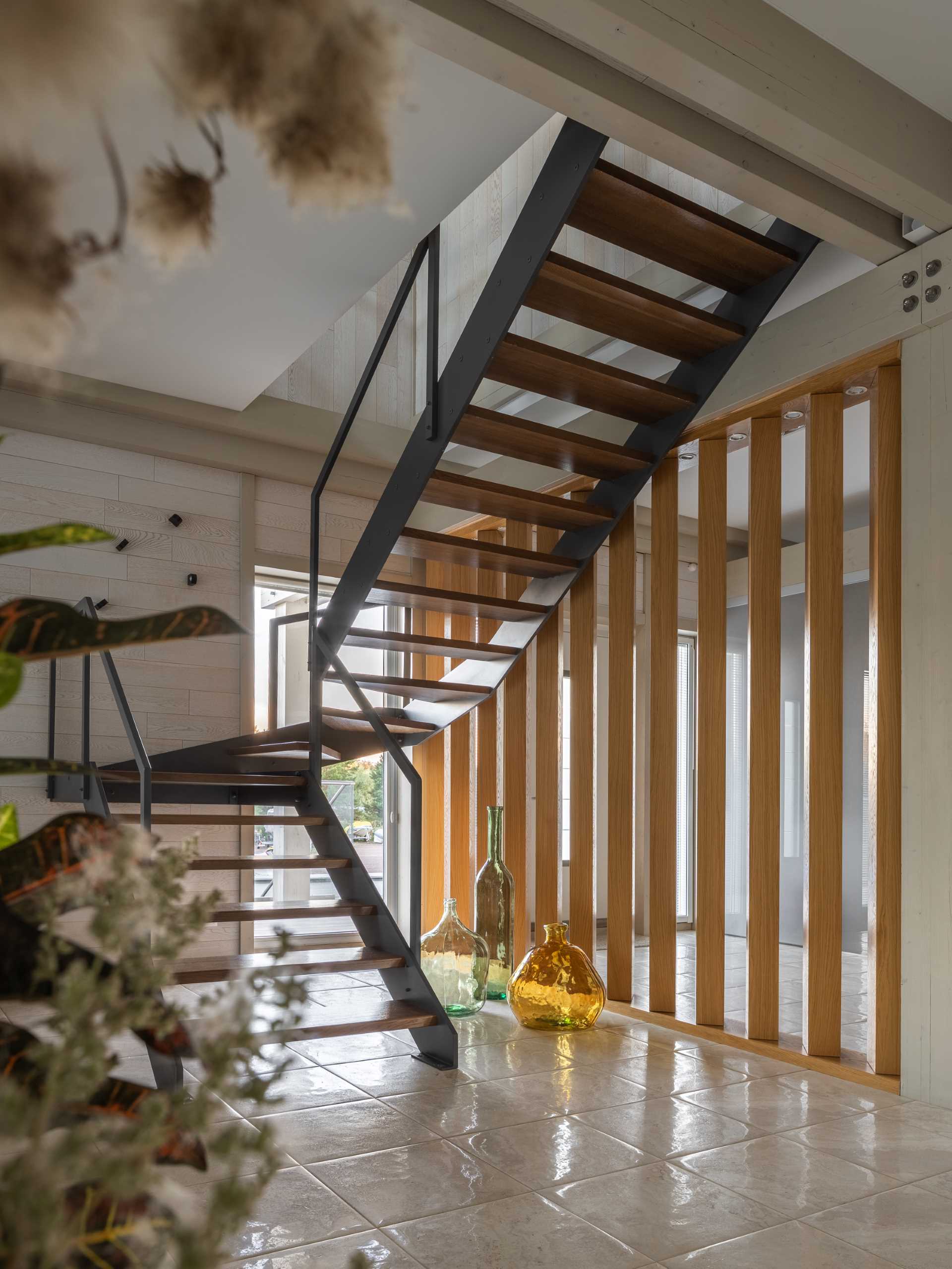 Steel and wood stairs connect the main floor with the upper floor of this ،me.