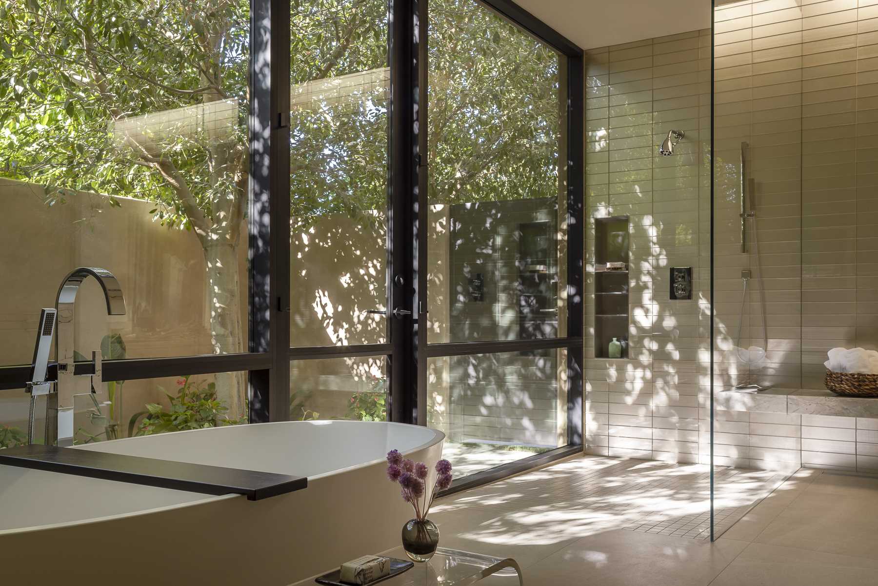 In a bathroom, skylights provide natural light, while the windows frame the tree views from the bath and the shower.