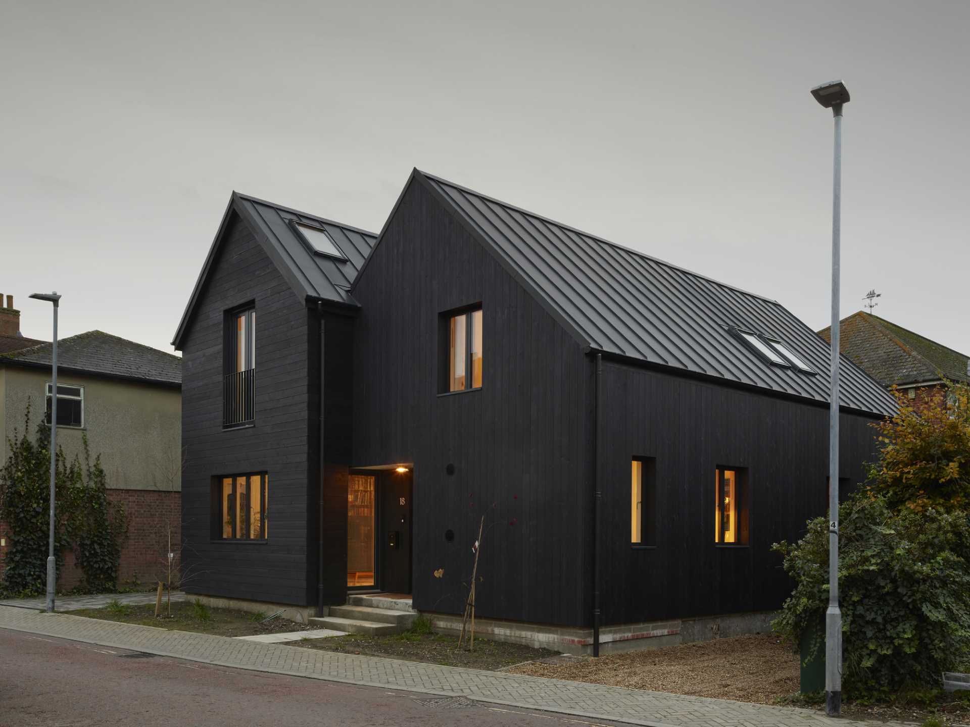 The exterior of the home features a double-gable roof, timber cladding in a dark colour, and metal cladding on the roof.
