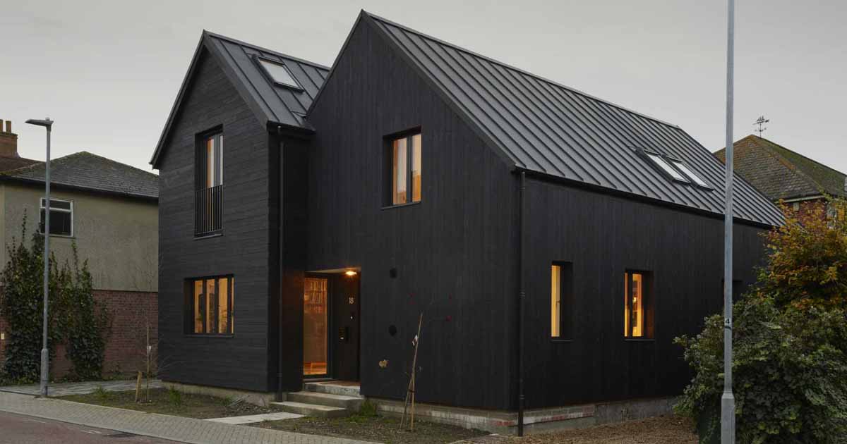 The Black Exterior Of This Home Leads To A Pink Kitchen Inside