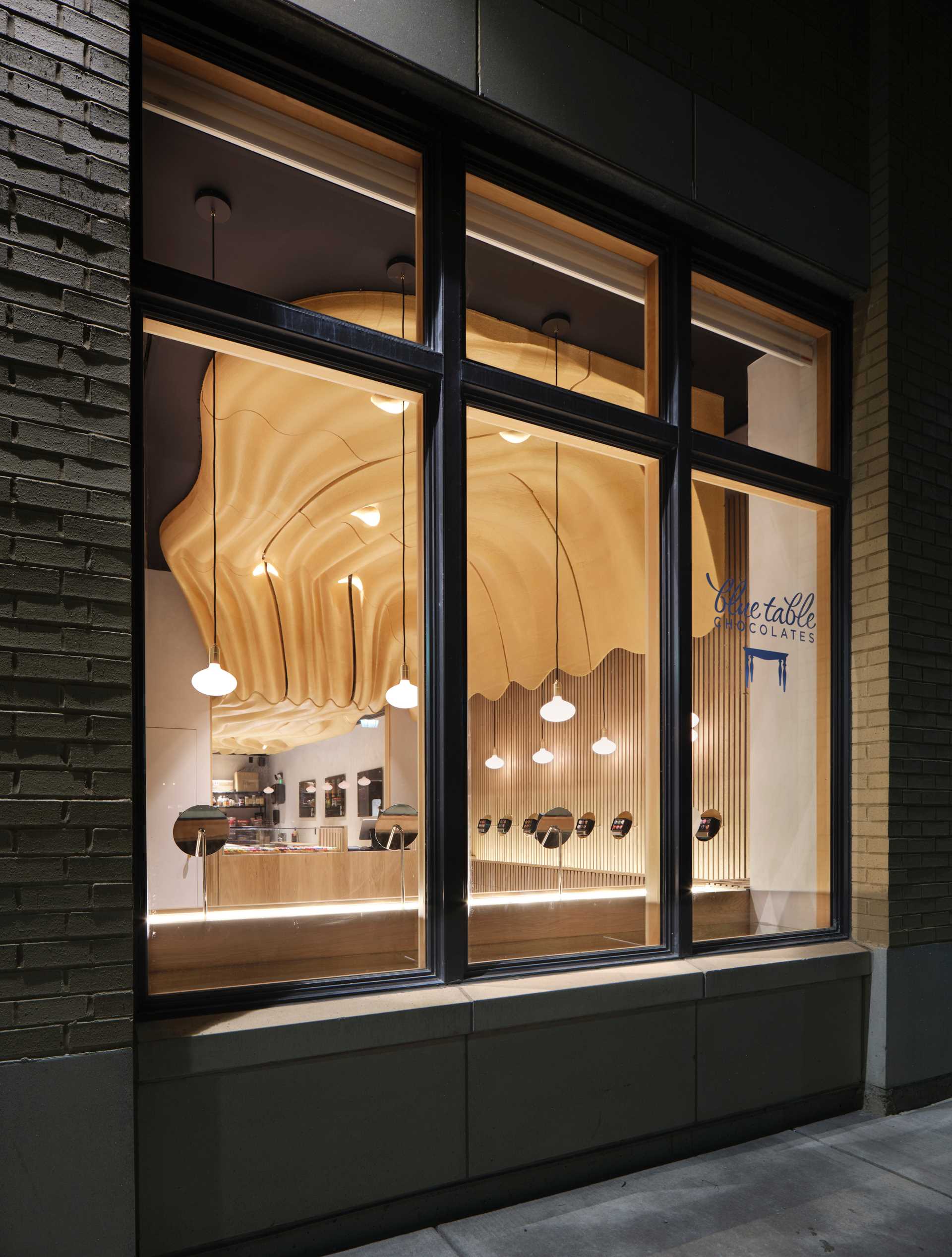 A modern retail chocolate store with a sculptural ceiling that was inspired by flowing untempered chocolate.