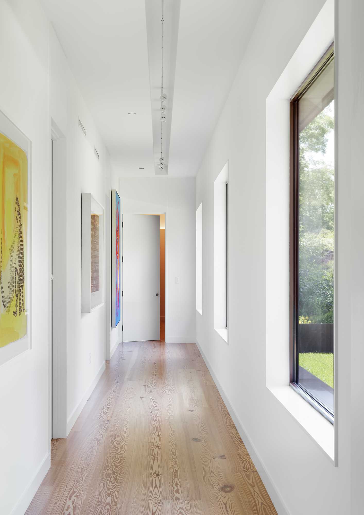 In the hallway, artwork adds a pop of color to the white walls.