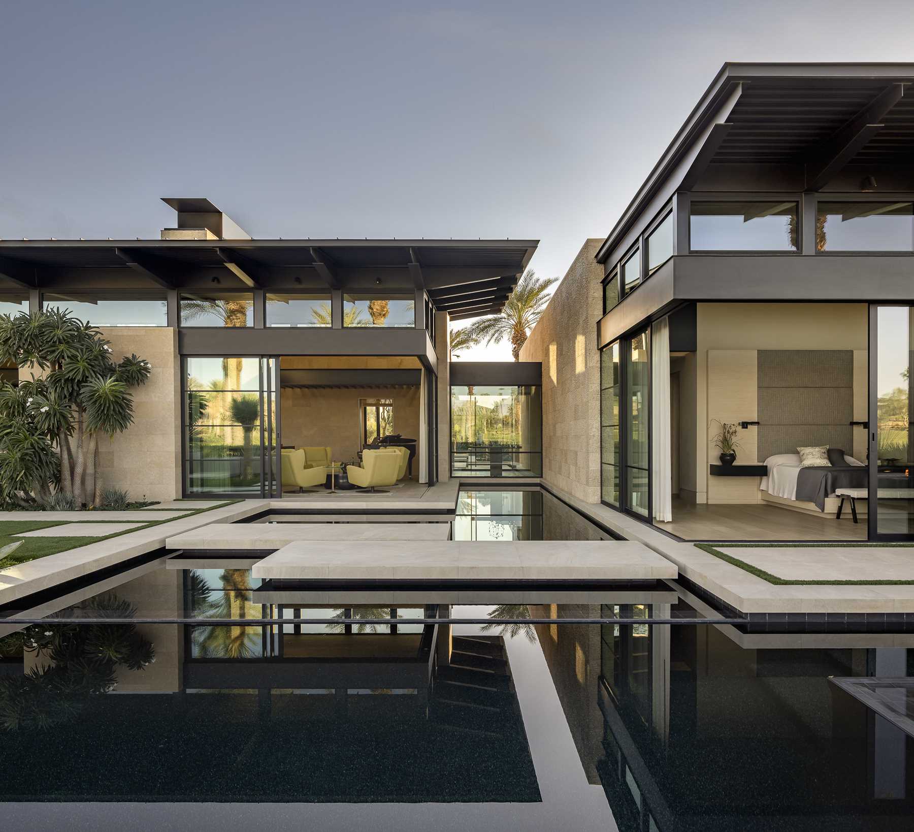 A modern home that opens to the outdoors, where reflecting ponds and concrete lily pads can be found.