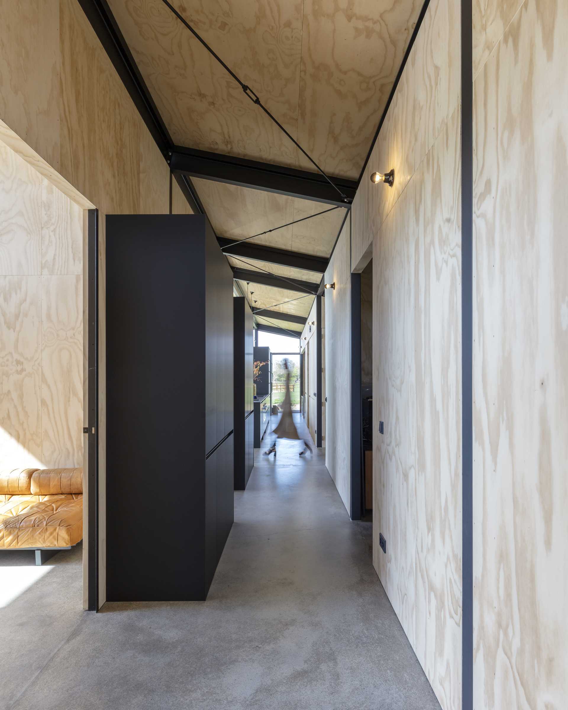 A modern house with a hallway that connects to the kitchen.