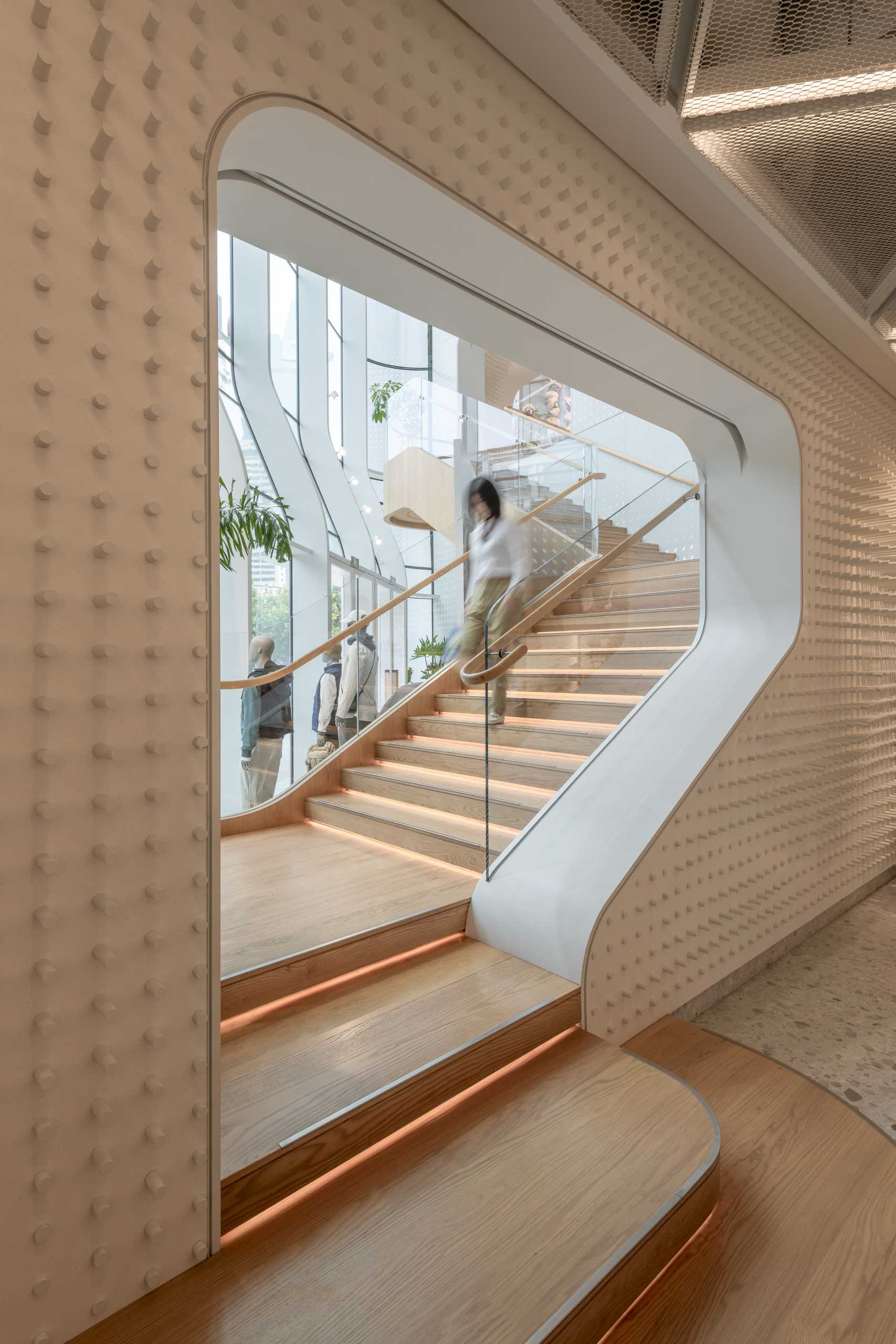 A modern Lululemon flag،p store has curved walls with a large staircase that connects the multiple floors.