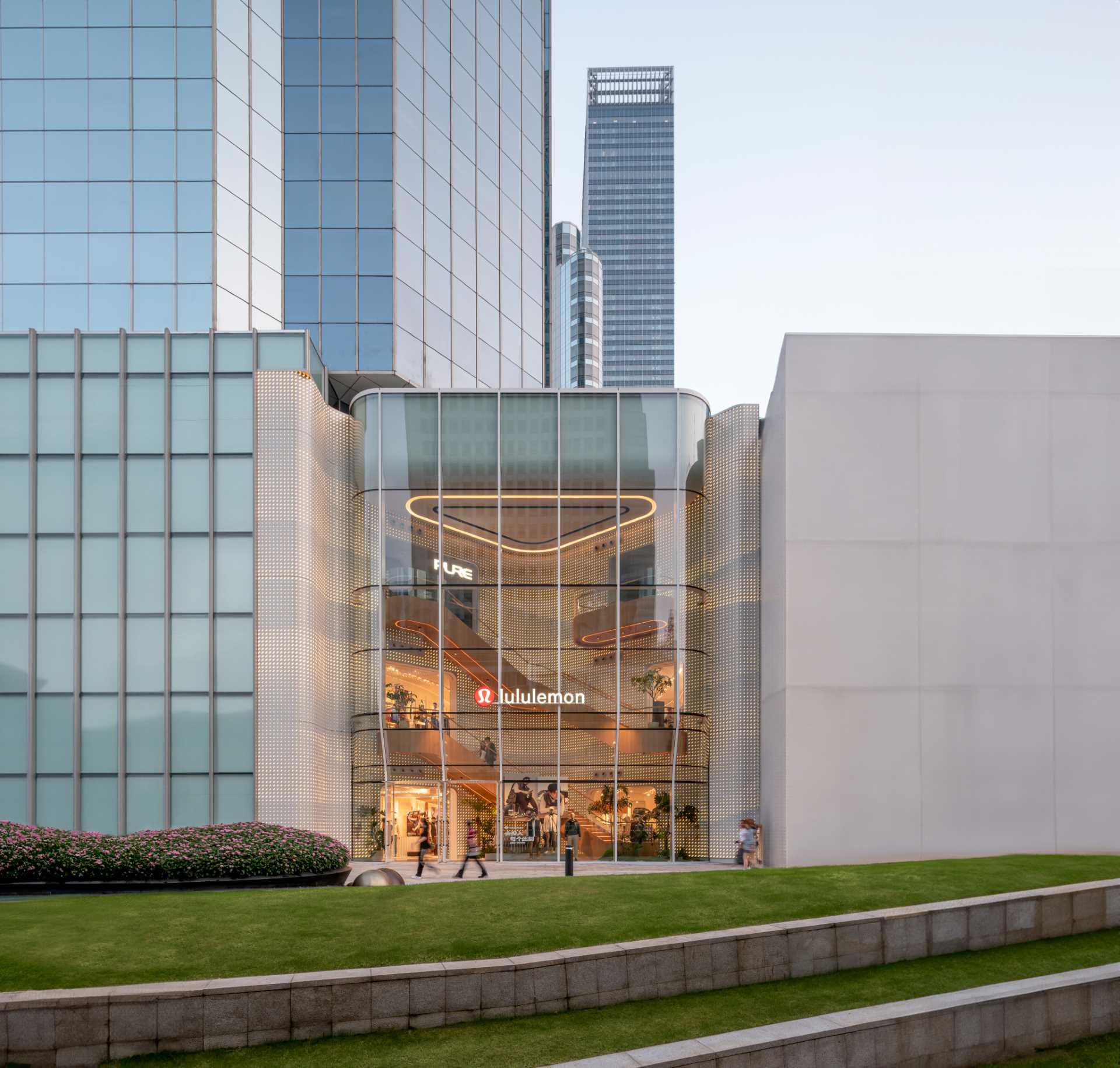 A modern Lululemon flagship store has a curved glass facade.