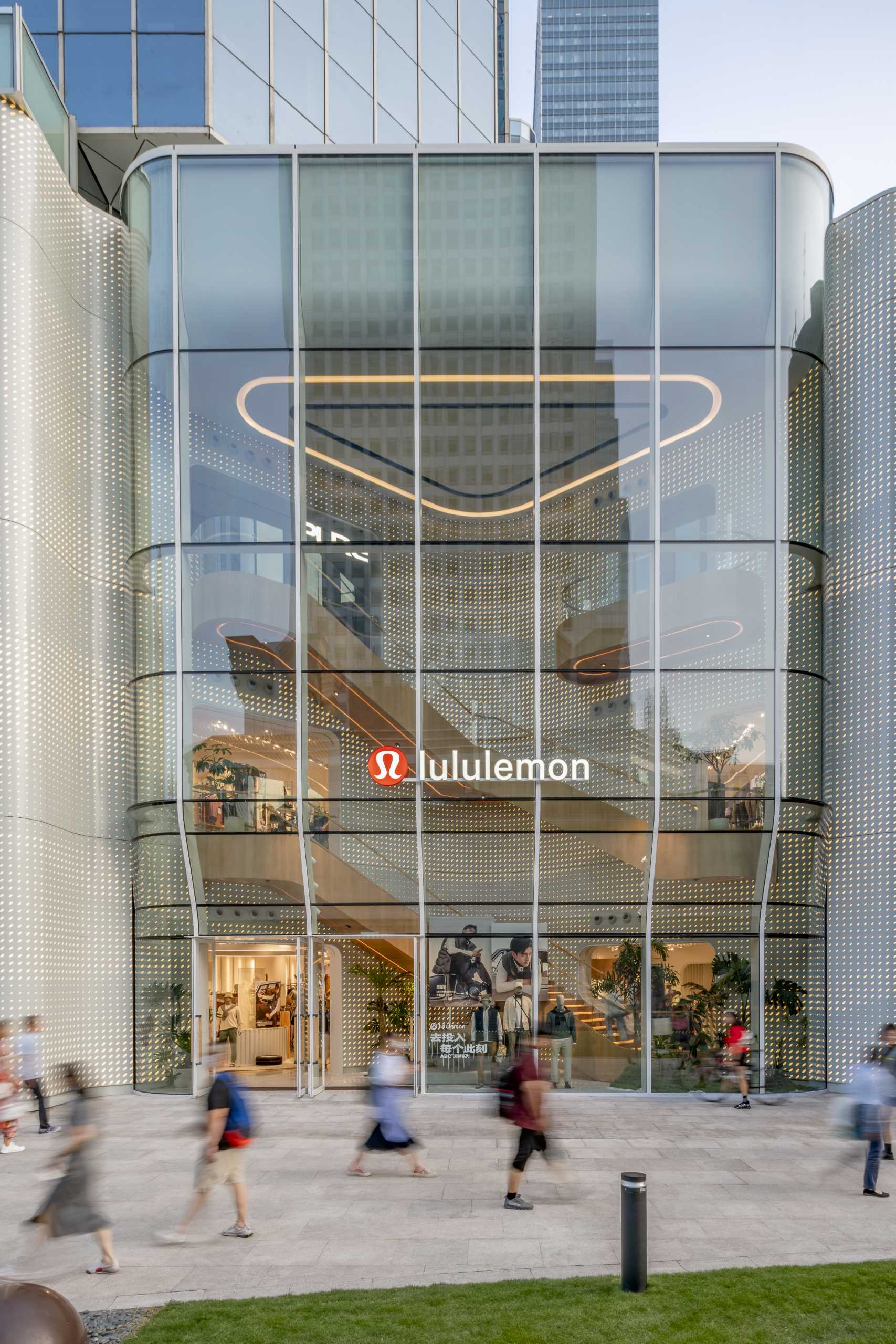 A modern Lululemon flagship store has a curved glass facade.