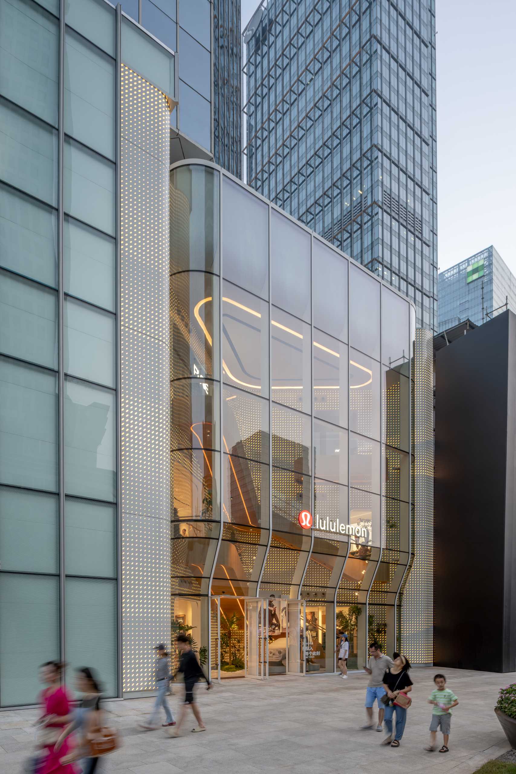 A modern Lululemon flagship store has a curved glass facade.