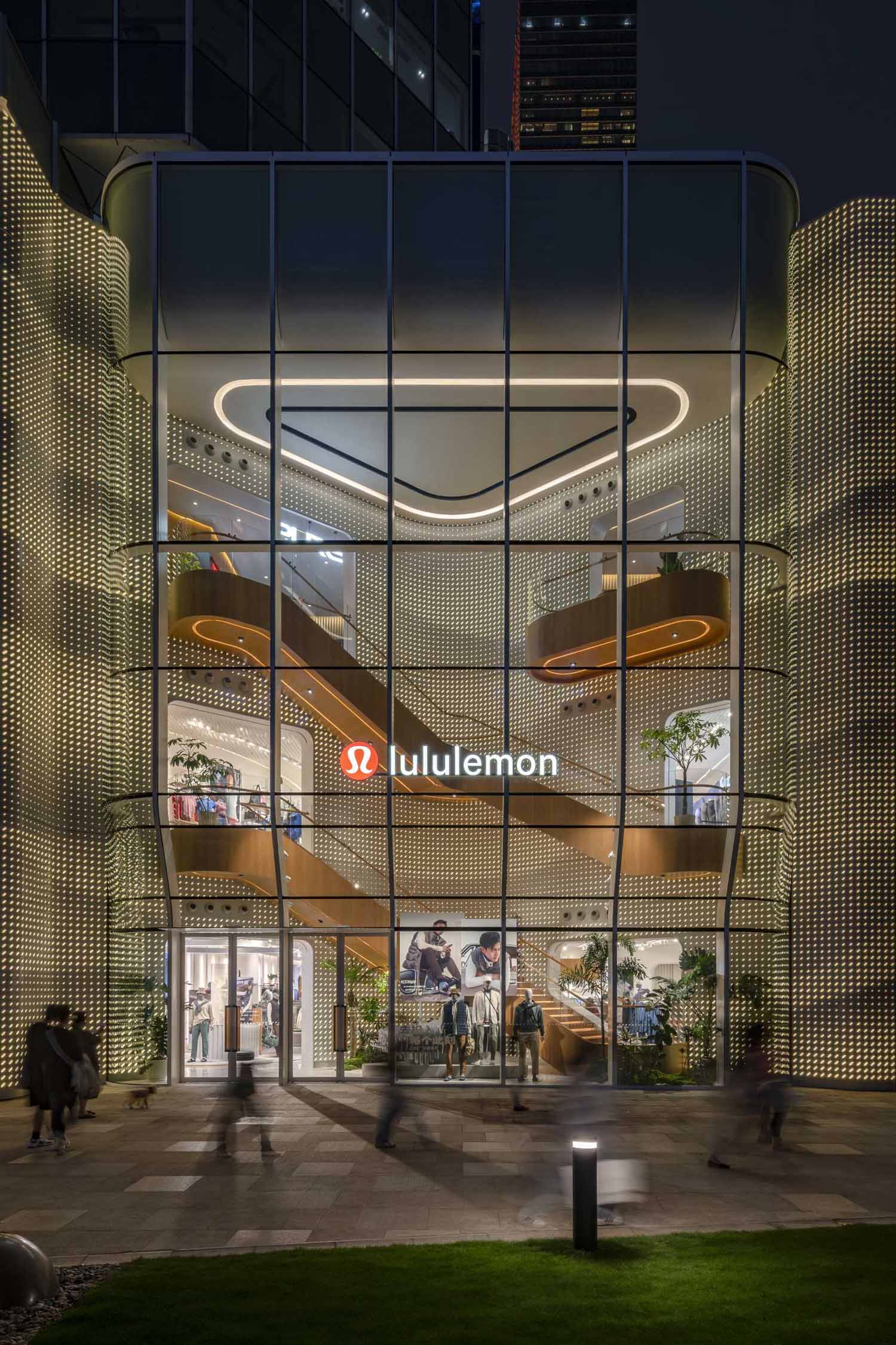 A modern Lululemon flagship store has a curved glass facade.