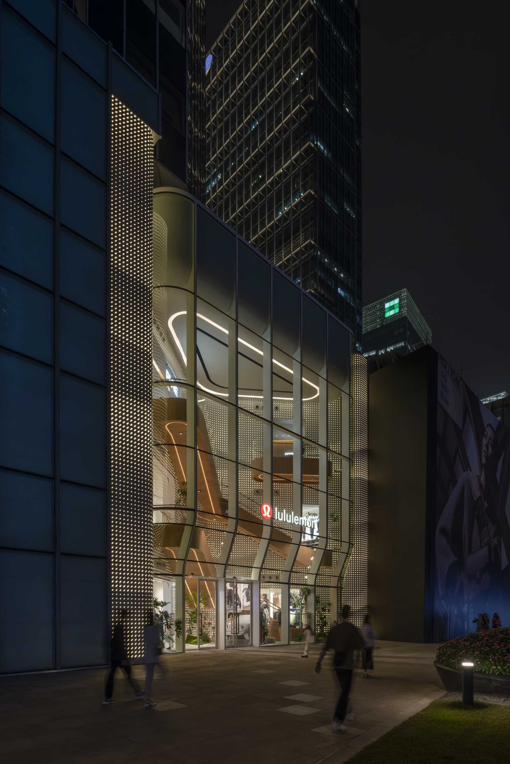 A modern Lululemon flagship store has a curved glass facade.