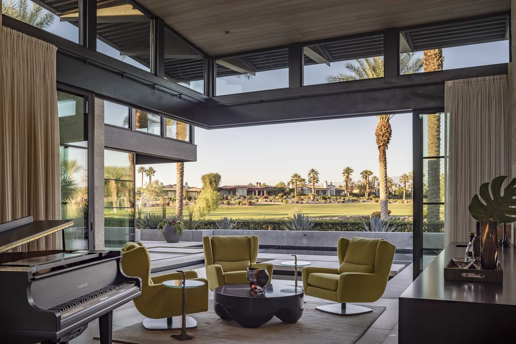 The interior ceiling of this modern ،use transitions from wood to steel decking at the exterior, meeting the owners' preference for durable materials in a harsh climate, while the gl، walls open to connect with the outdoors.