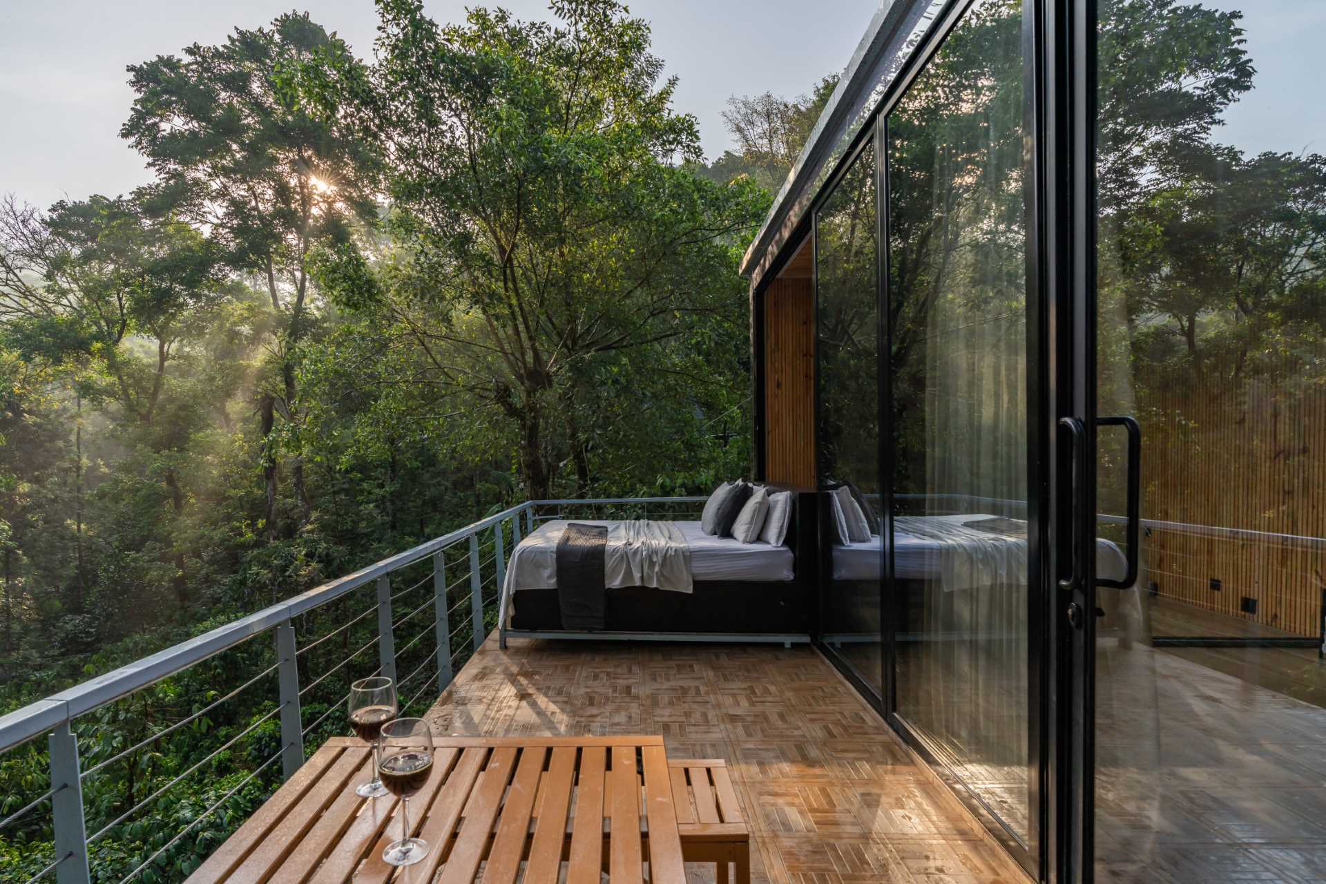 A small and modern cabin with a mirrored facade, also includes a slide-out bed that can be inside or outside on the deck.