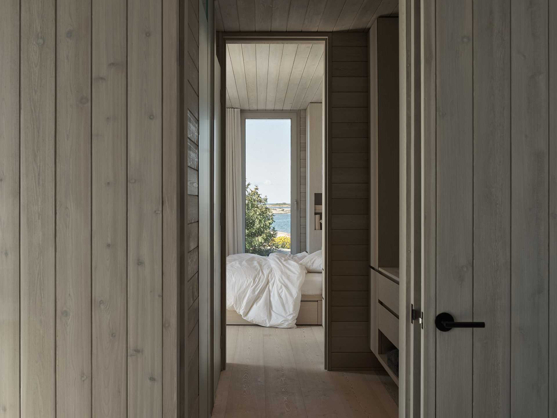 A contemporary bedroom with a wood bed frame and white bedding.