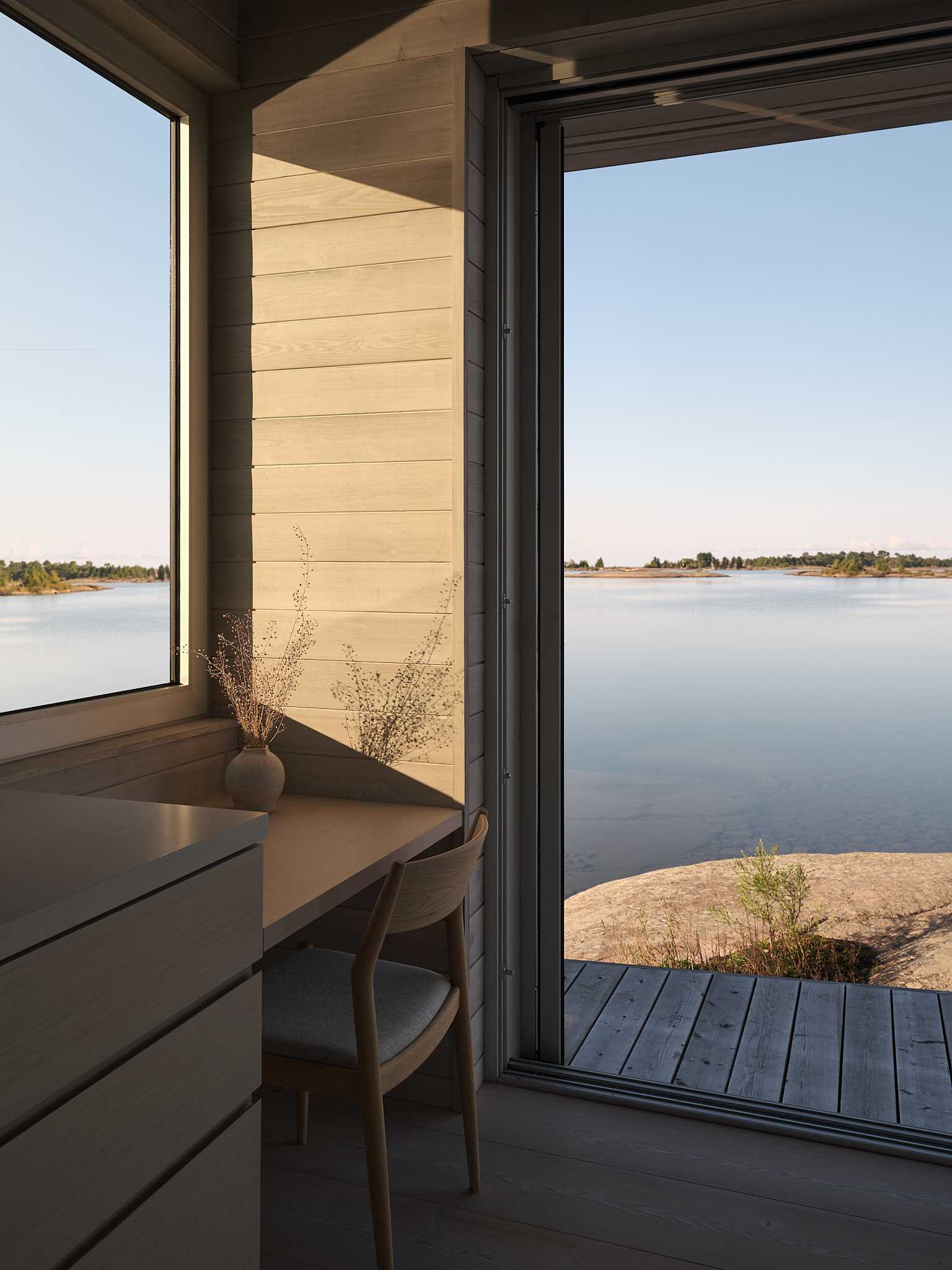 The bunkie is a smaller version of the cottage, designed to sleep up to four in two bedrooms with a shared bathroom. A large flagstone fireplace at its core separates the bedrooms from a kitchenette with a desk and lounge area with a pair of loveseats.