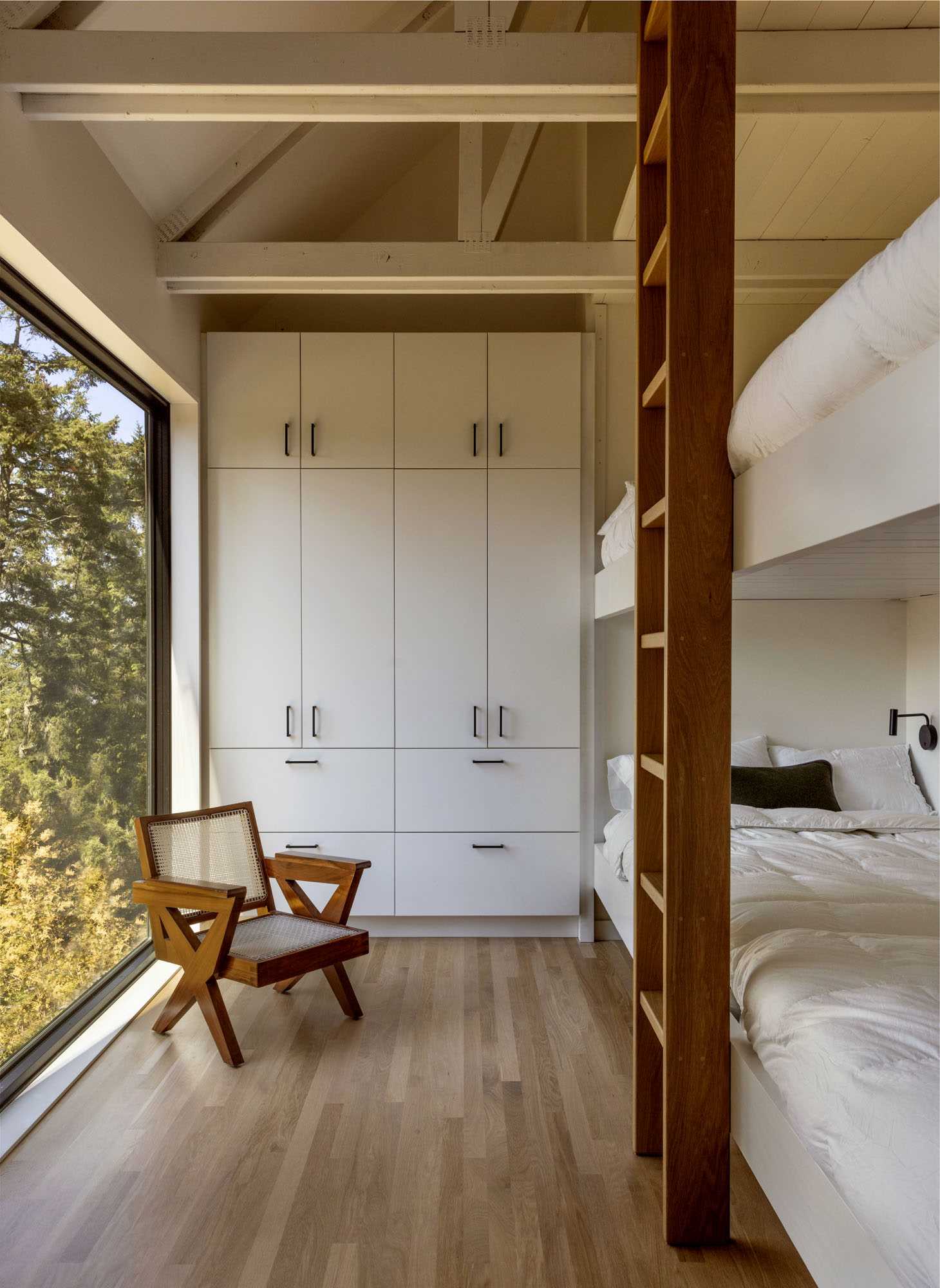 A modern bunk room with built-in beds and storage.