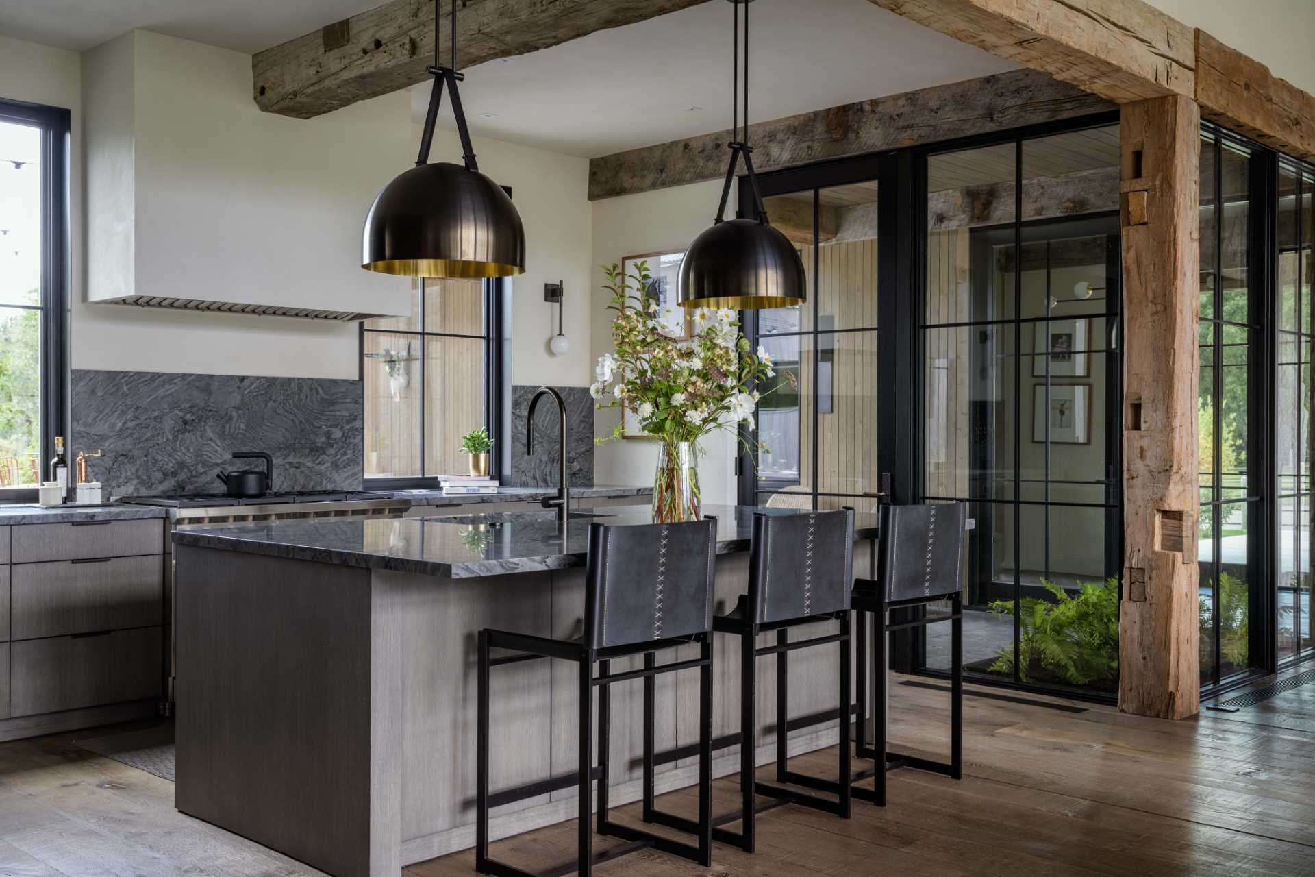 A custom kitchen with dark countertops and finishes blends modern with rustic.