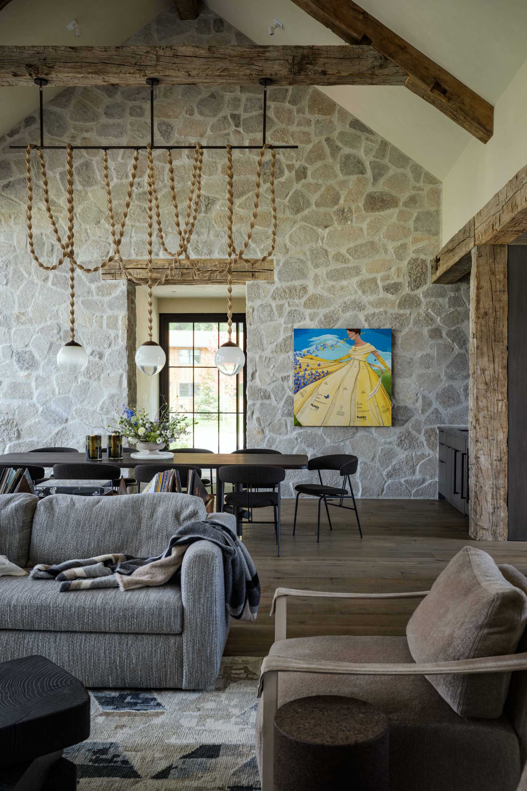 Floor-to-ceiling stone creates a rustic and European feel in the living/dining area.