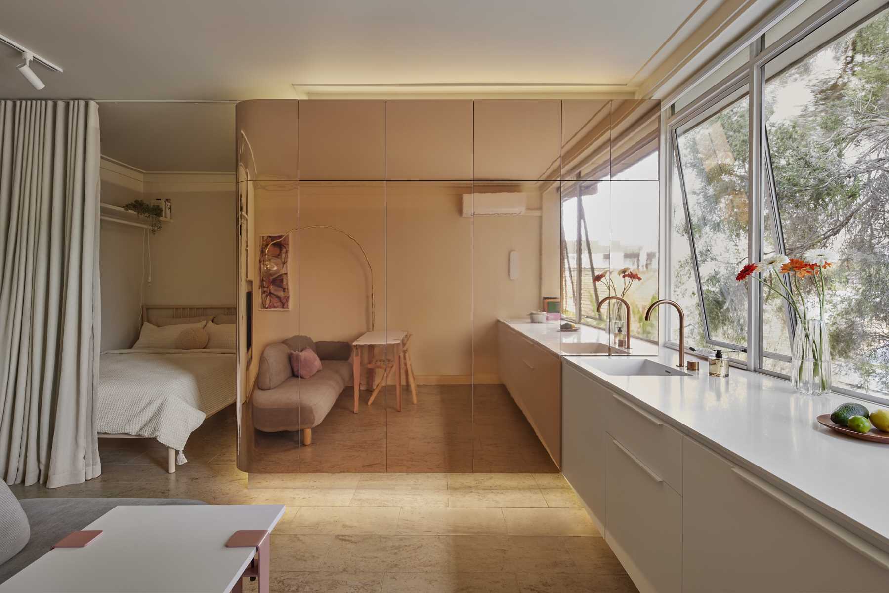 A micro-apartment with a brass clad pod includes storage and a bathroom.