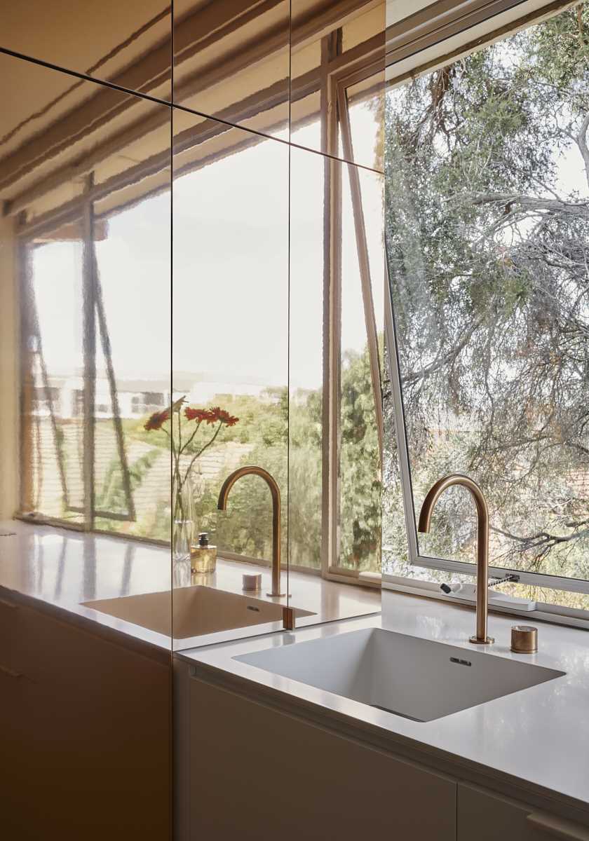 The kitchen countertop has a built-in seamless sink with brass hardware.